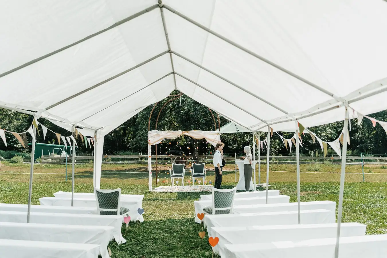 White event tent set with chairs for an outdoor gathering